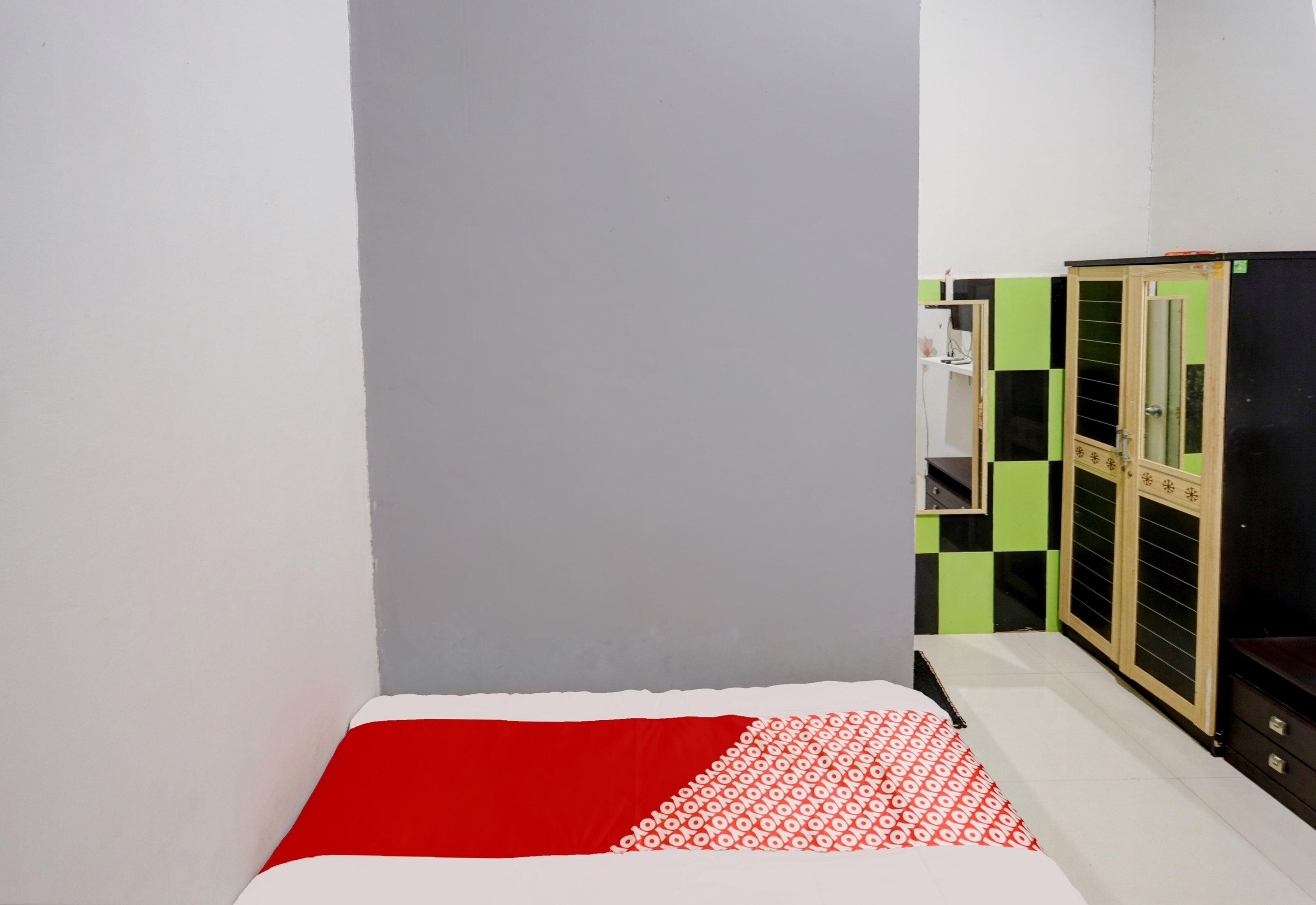 Un dormitorio con cama, armario y espejo.
