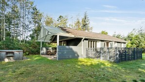 A single-story house with a sloped roof, a covered porch, and a fenced yard. - "Arwin" - 200m from the sea by Interhome (Hadsund)