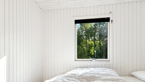 A bedroom with a large window, white walls, and a bed with a white duvet. - "Arwin" - 200m from the sea by Interhome (Hadsund)