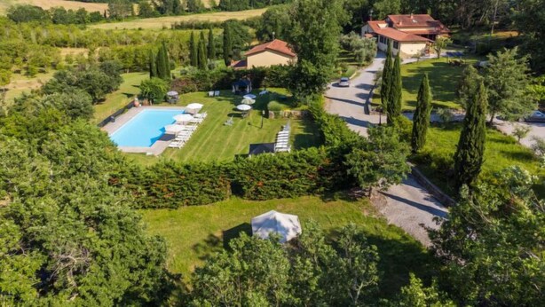 Une villa avec piscine, entourée d’une végétation luxuriante et de collines.