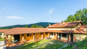 Une villa traditionnelle dotée d’une cour intérieure, d’un chemin en pierre et d’un espace extérieur aménagé pour s’asseoir.