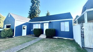 Een blauw, gelijkvloers huis met een voordeur, een klein portaal en het nummer '1712' op de deur.