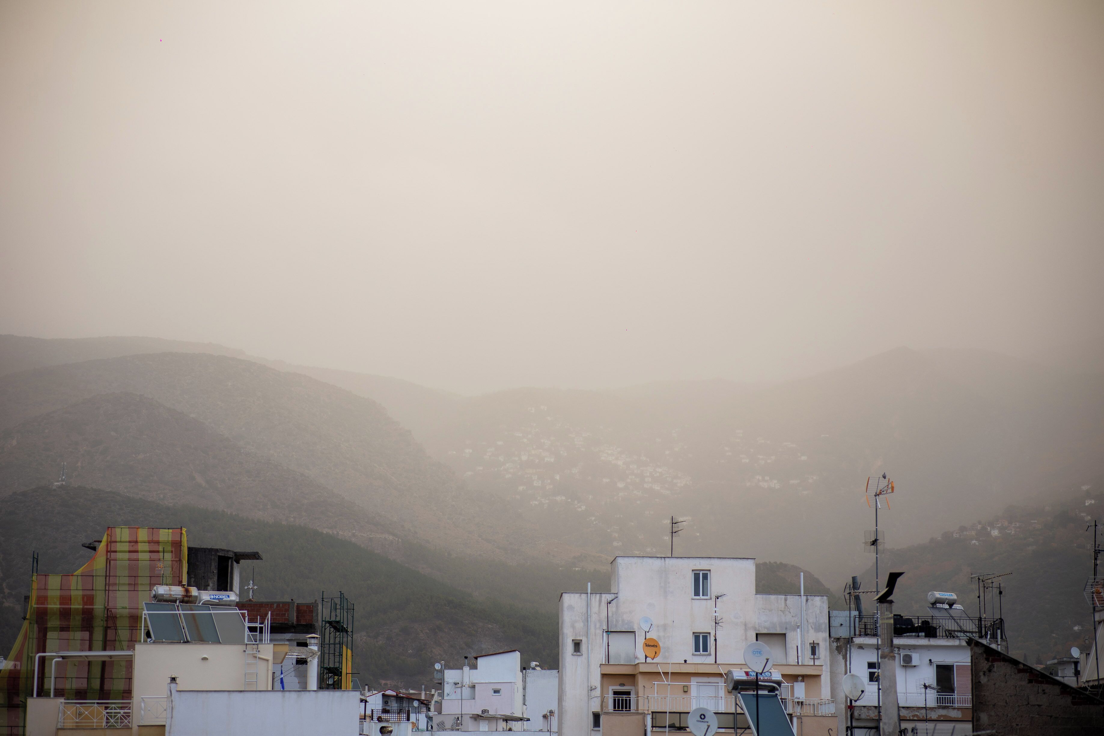 Zona residencial con edificios y montañas al fondo.