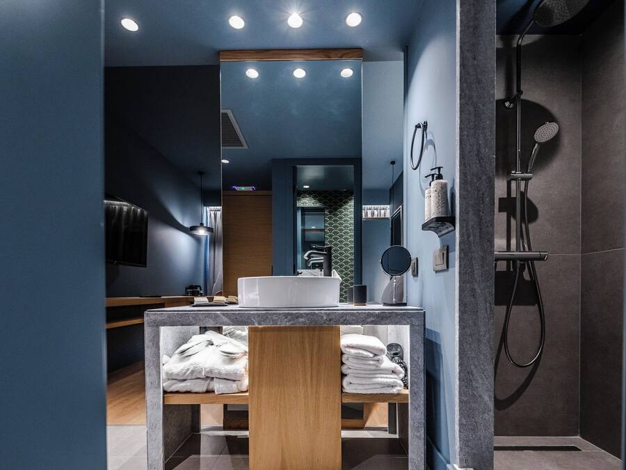 Un bany modern amb un lavabo, una aixeta i una dutxa.