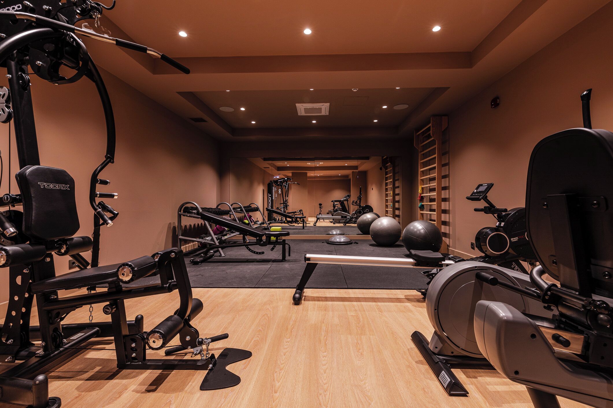 A gym with various exercise equipment, including a treadmill, stationary bike, and weight machines.