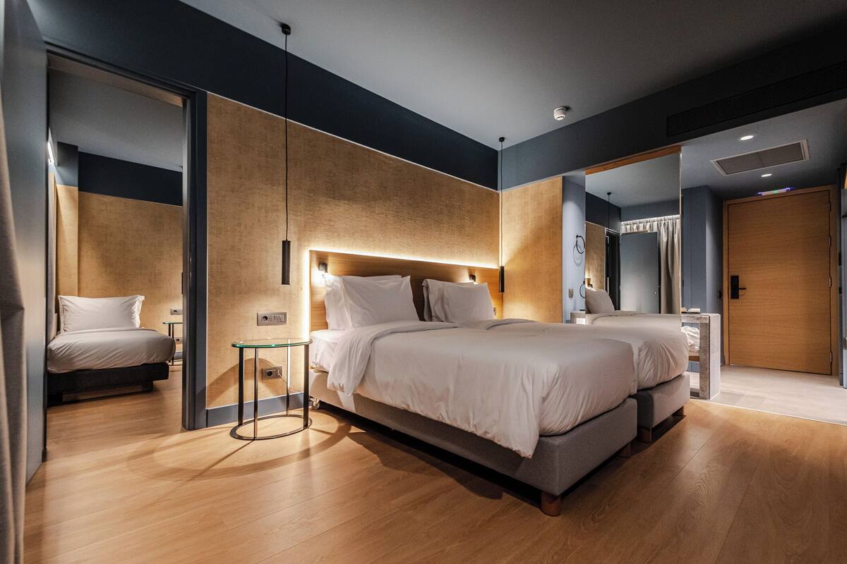 Un dormitorio moderno con una cama grande, mesitas de noche y un espejo.