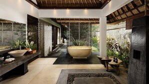 Une salle de bain moderne avec une grande baignoire, deux lavabos et un mur en pierre.