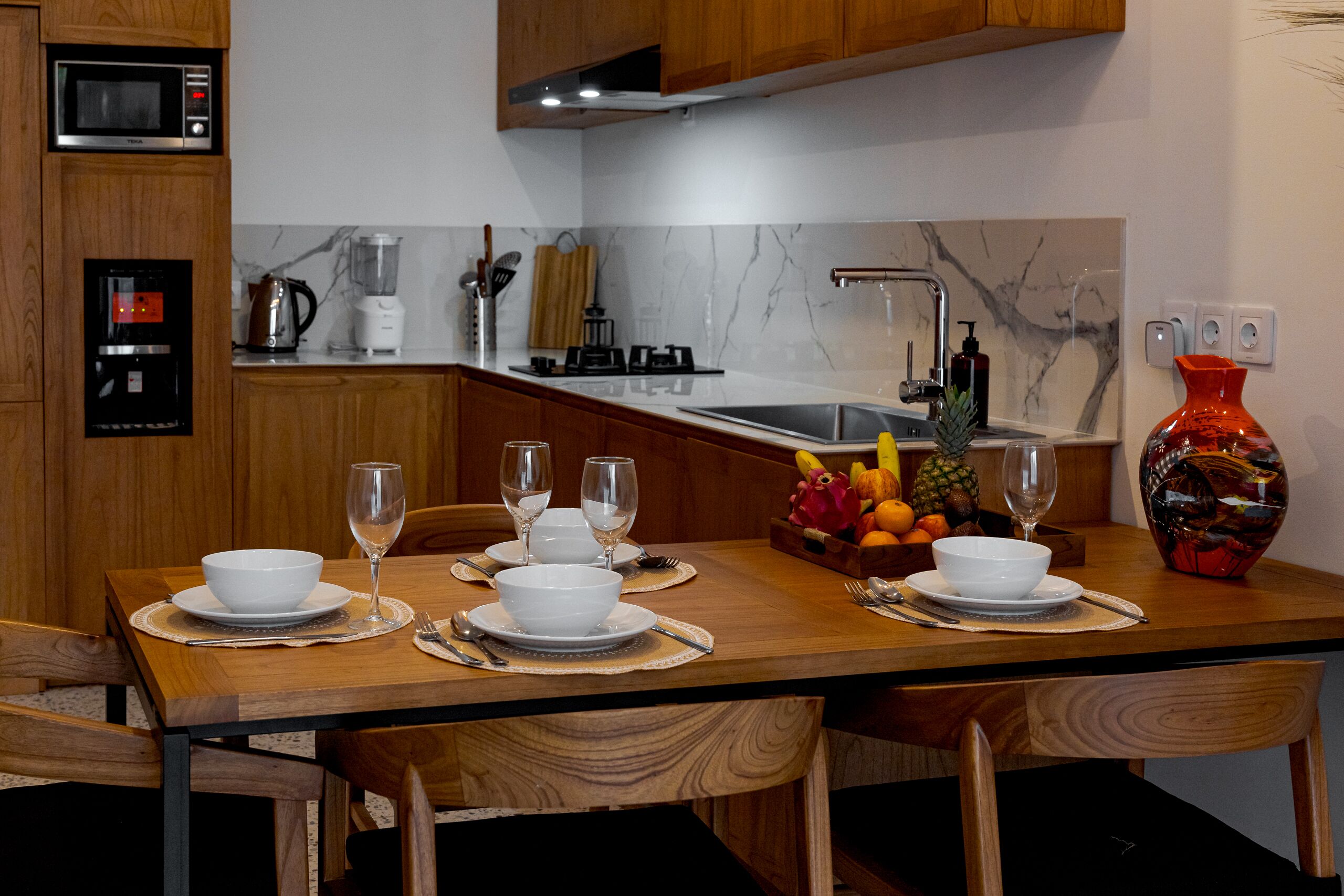 A modern kitchen with wooden cabinets, a built-in microwave, and a sink.