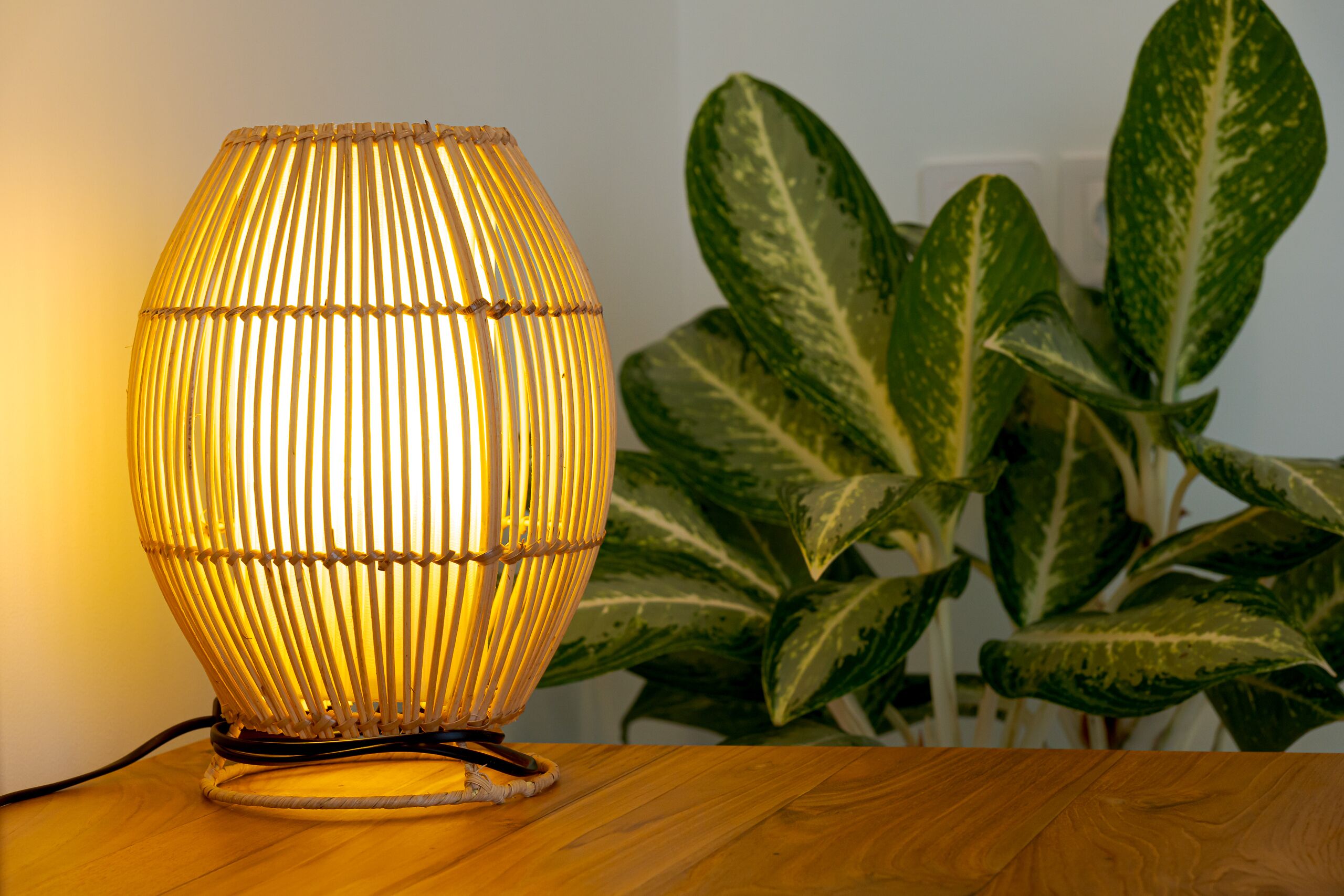Une lampe à abat-jour à motifs en relief, posée sur une surface en bois.