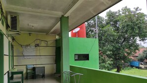 A balcony with a green wall, a satellite dish, and a small window. - OYO 90333 Wisma Tenang Jaya Syariah (Jatiwangi)