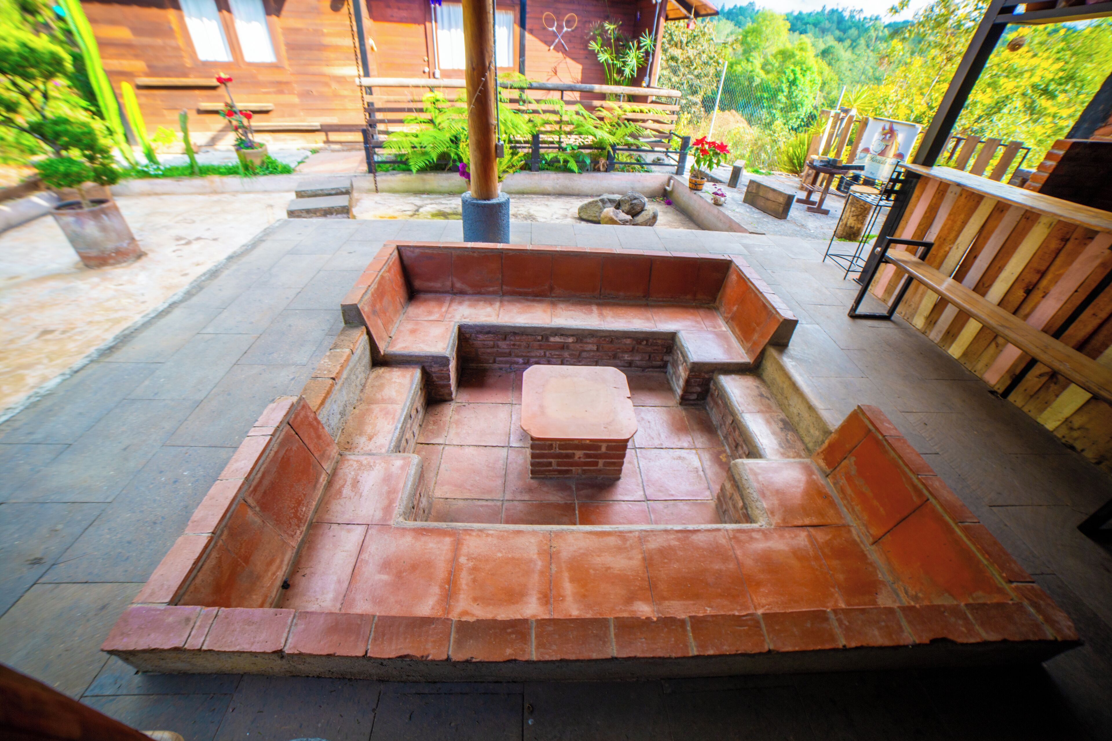 A patio area with a built-in seating arrangement and a fire pit.