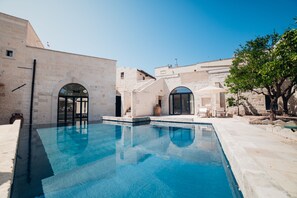 Una piscina con arquitectura de piedra y arcos.