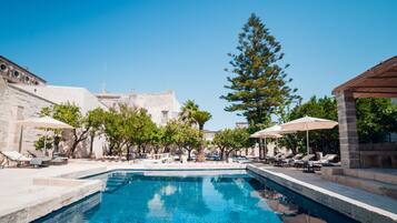 Een seizoensgebonden buitenzwembad en parasols bij het zwembad