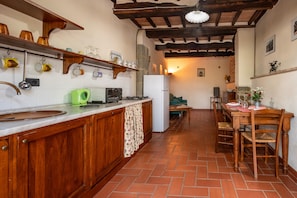 A kitchen with wooden cabinets, a countertop, a sink, a green kettle, a stove, and a refrigerator. - Farmhouse "Piamperugino" with Shared Pool, Private Garden & Wi-Fi (Arcidosso)