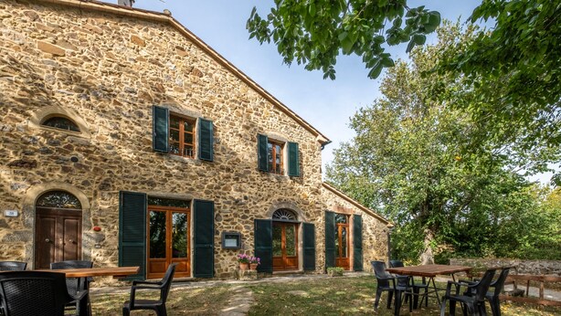 A stone building with a courtyard, outdoor seating, and a tree. - "Ginestra" Apartment in Farmhouse with Shared Pool, Mountain View, and Wi-Fi (Arcidosso)