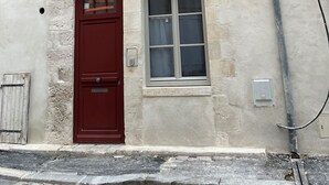 A building with a traditional half-timbered facade, a red door, and a window with a white frame.