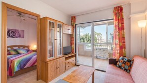 Une chambre avec un lit, une télévision, une armoire en bois et un balcon avec vue.
