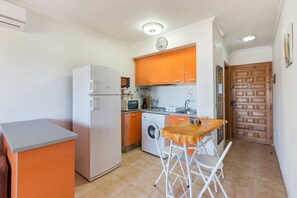 A compact kitchen with a washing machine, a microwave, and a sink.
