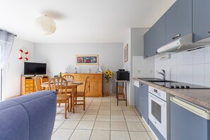 Une cuisine compacte avec un coin repas, un téléviseur et un canapé.