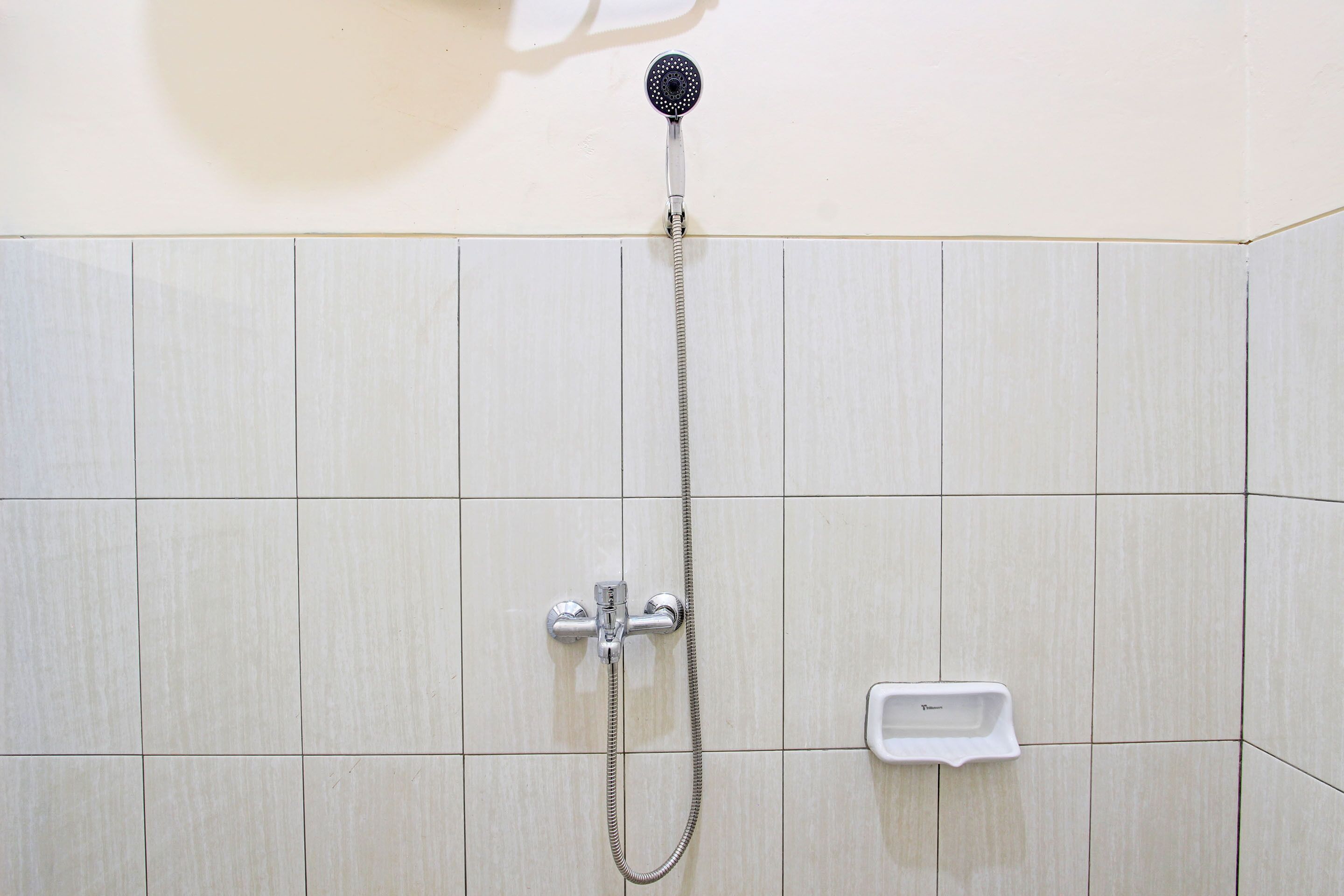 A shower with a handheld showerhead and a handheld faucet.