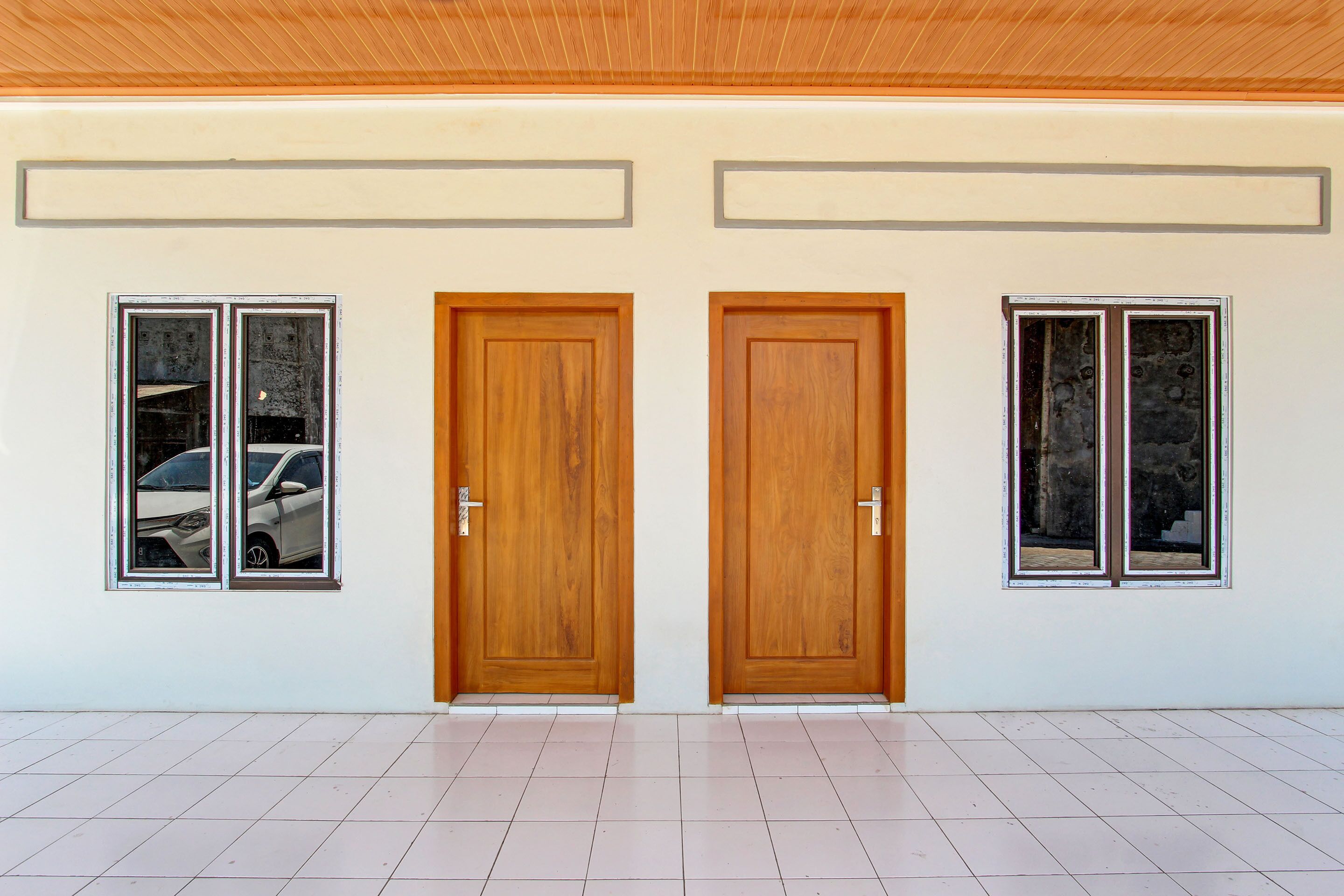 Un corridoio con due porte in legno e finestre su entrambi i lati.