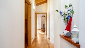 A hallway with wooden flooring, a gnome decoration, and a white lantern on a shelf. - Chalet 'Maso Gigi' with Mountain View, Private Garden and Wi-Fi (Ivano fracena)