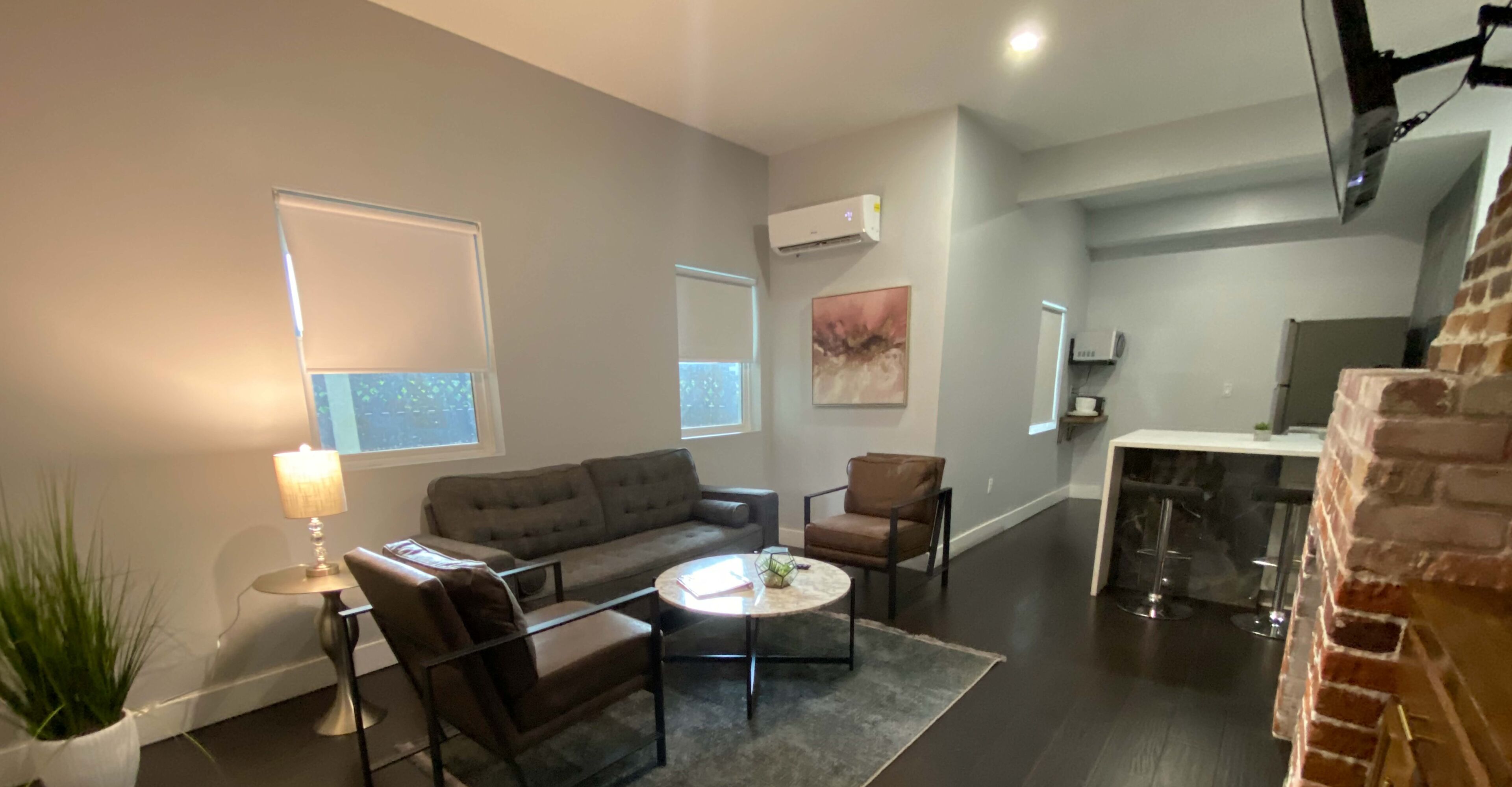 A modern living room with a sofa, chairs, a coffee table, and a fireplace.