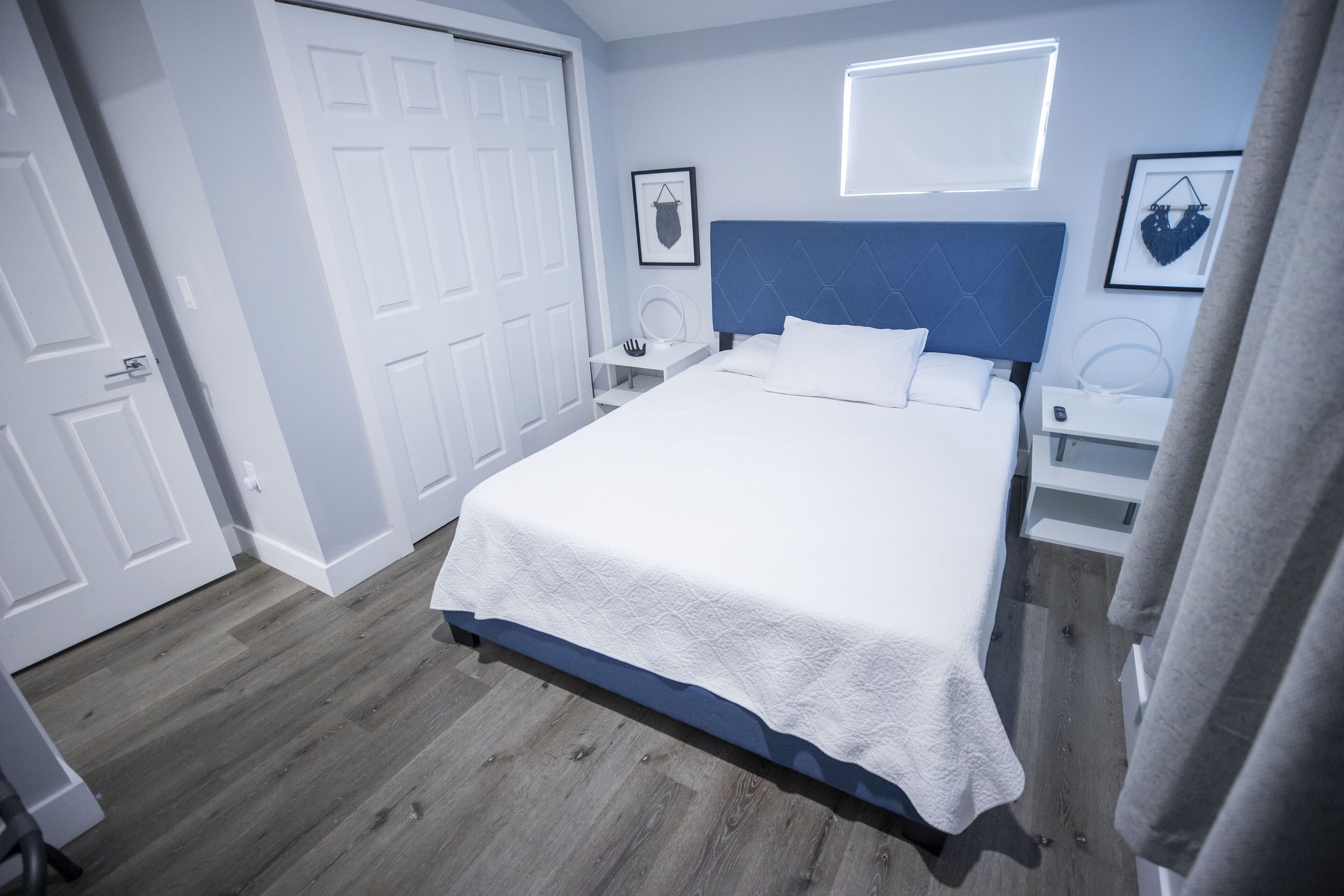 Un dormitorio con cama, mesitas de noche, armario y espejo.
