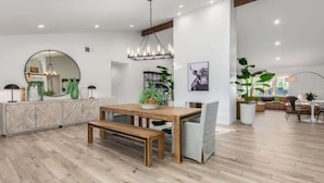 A spacious room with a wooden dining table, bench, and a large mirror on the wall. - The Larkspur|2 Masters|Heated Pool|Gameroom (Scottsdale)