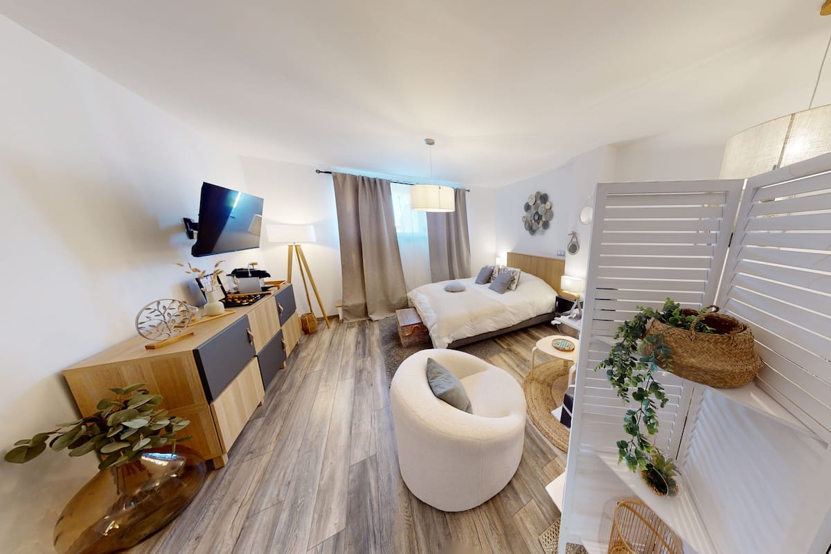 Een moderne hotelkamer met een bed, een bureau, een stoel en een televisie.