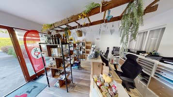 A cozy interior with wooden shelves, a desk, and hanging plants.