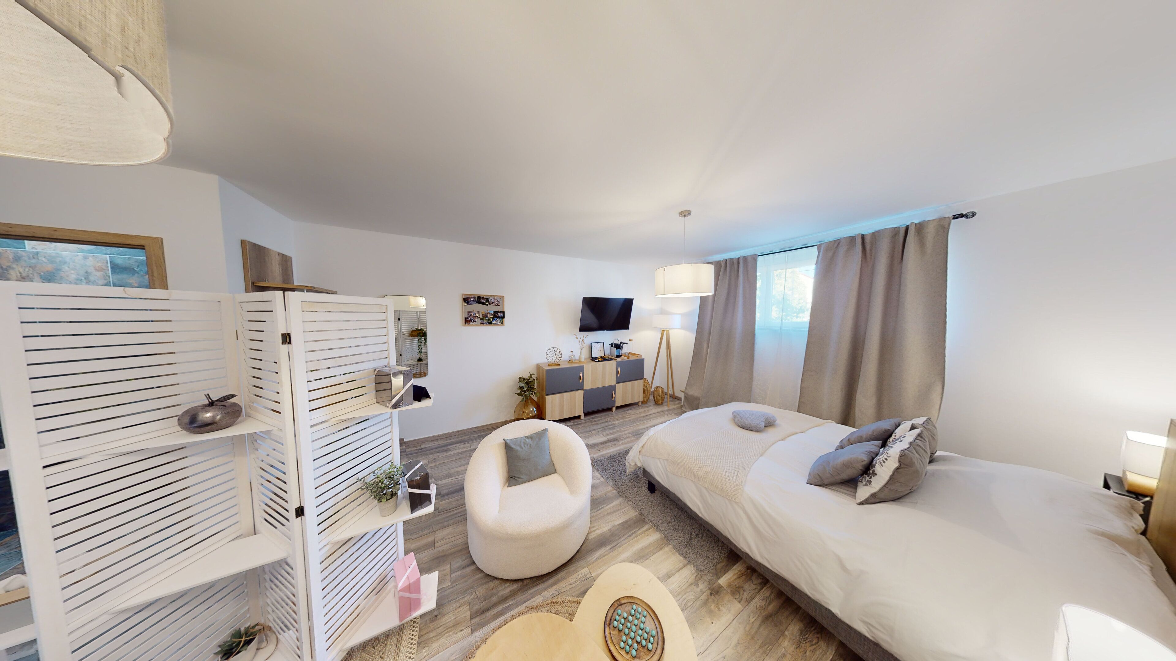 Una habitación de hotel moderna con una cama, un sofá, un televisor y un mueble de madera.