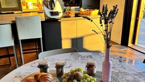 Une table mise pour le petit-déjeuner, avec des croissants, des raisins et une tasse de café.