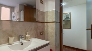Ein Badezimmer mit Waschbecken, Spiegel und Duschbereich.