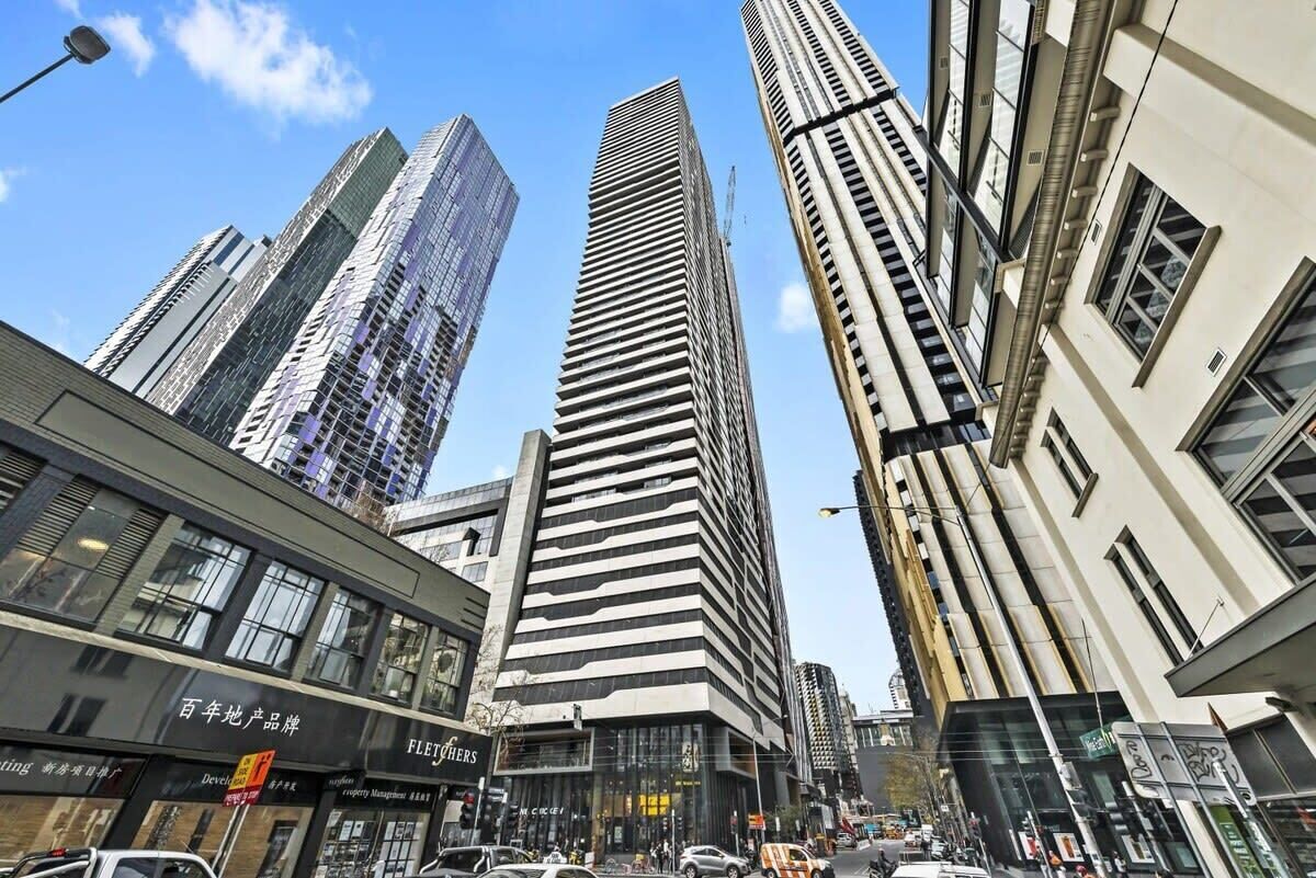 A cityscape with modern high-rise buildings, a street with cars, and storefronts including one with 'FLEETERS' signage.