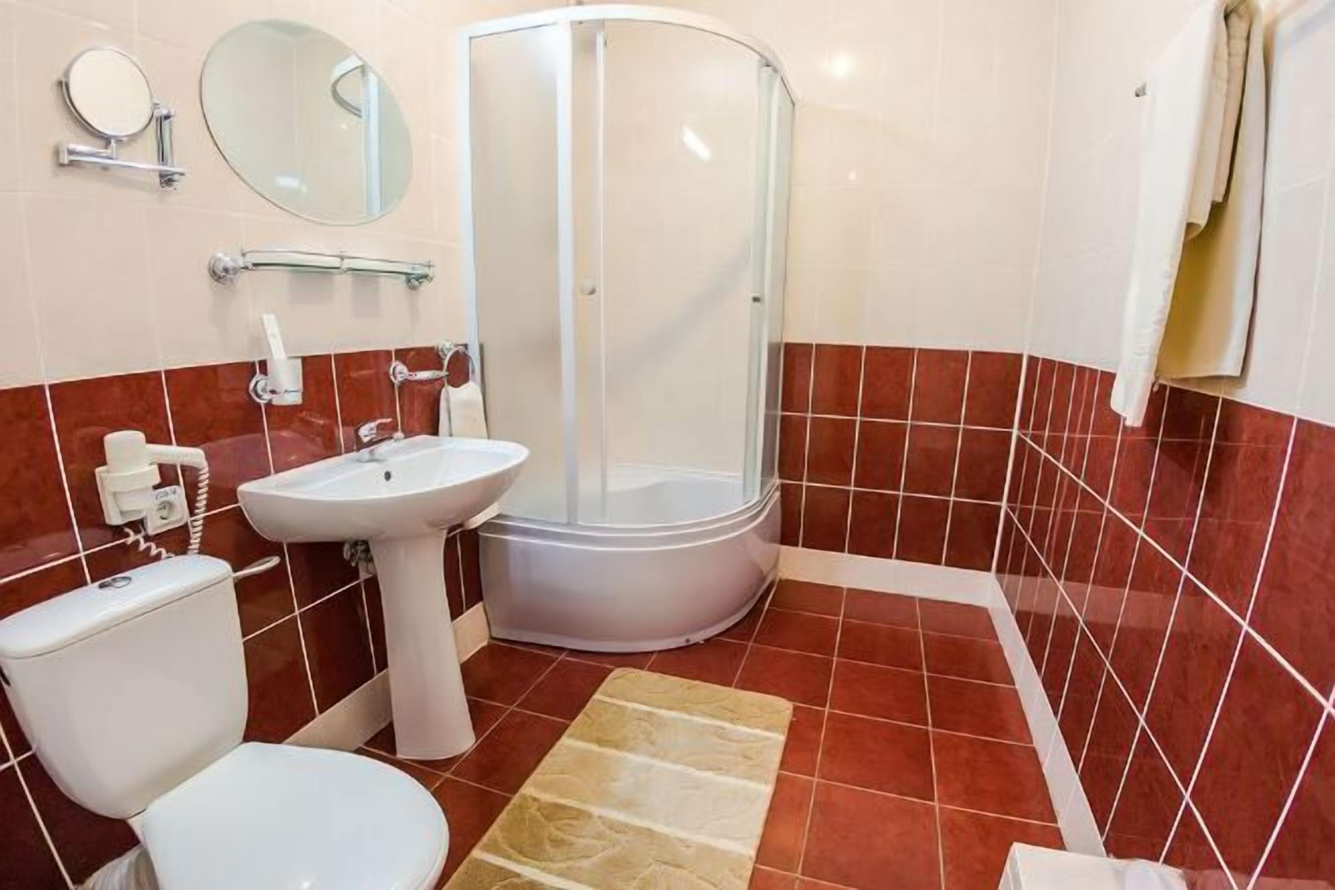 Badkamer | Een bad/douchecombinatie, een haardroger, badjassen, handdoeken