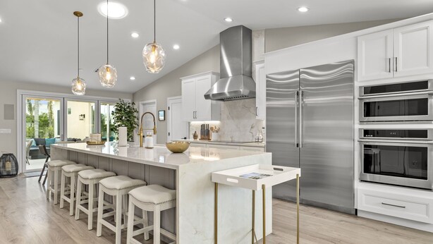 A modern kitchen with a central island, stainless steel appliances, and pendant lighting. - Elegant Renovated Home W/ Backyard Misters & Pool (Phoenix)