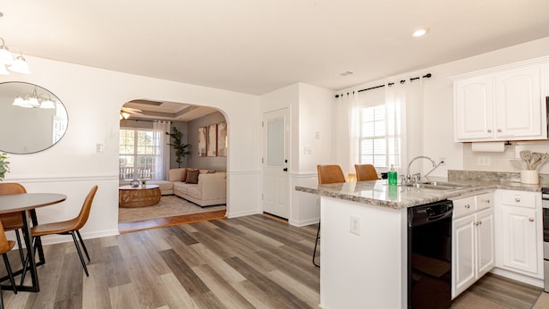 A modern kitchen with white cabinets, a granite countertop, and a dishwasher. - Comfortable 3BR | Screened Patio + Grill | WR (Warner Robins)