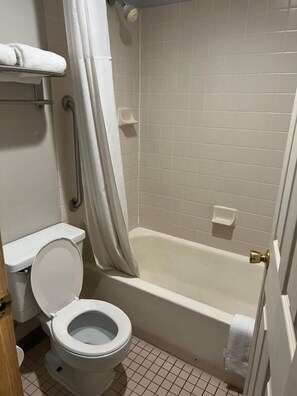 A bathroom with a toilet, a bathtub, and a shower curtain. - Red Roof Inn Charleston - Dunbar (Dunbar)