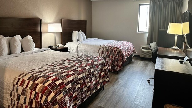 A hotel room with two beds, a desk, and a window with curtains. - Red Roof Inn Charleston - Dunbar (Dunbar)