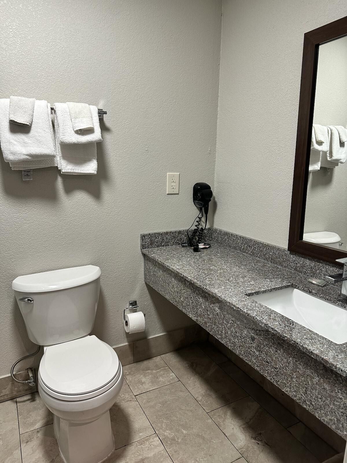 Ein Badezimmer mit Toilette, Waschbecken und Handtuchhalter.