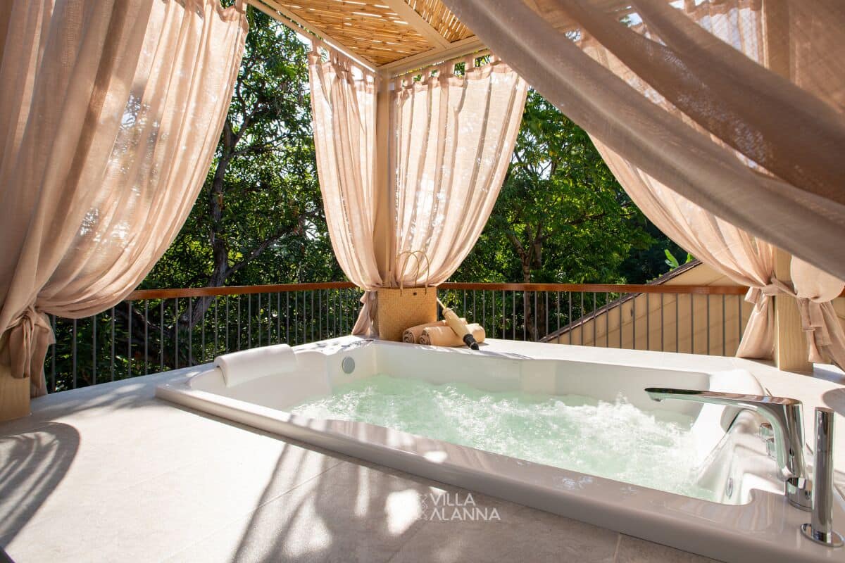 Un jacuzzi con cubierta de madera y vista a árboles.