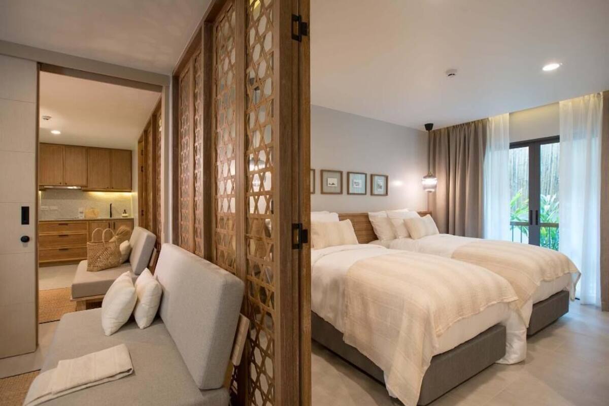 Un dormitorio moderno con una cama grande, un sofá y vistas a la cocina.