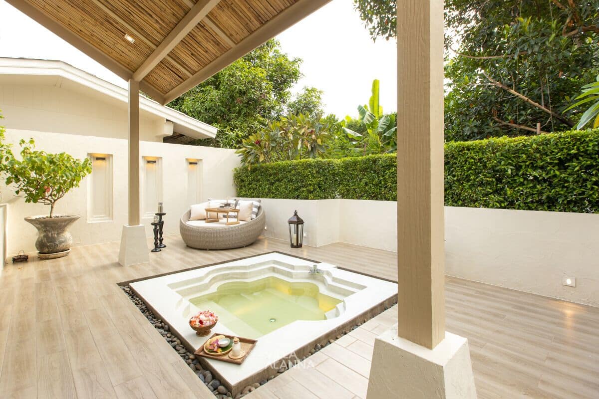 Zona de spa con hidromasaje, asientos y una planta en maceta.
