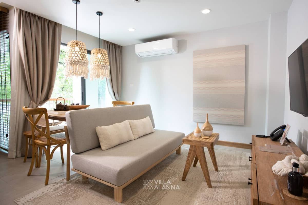 Una sala moderna con sofá, sillas de madera, una mesa de comedor y un televisor.