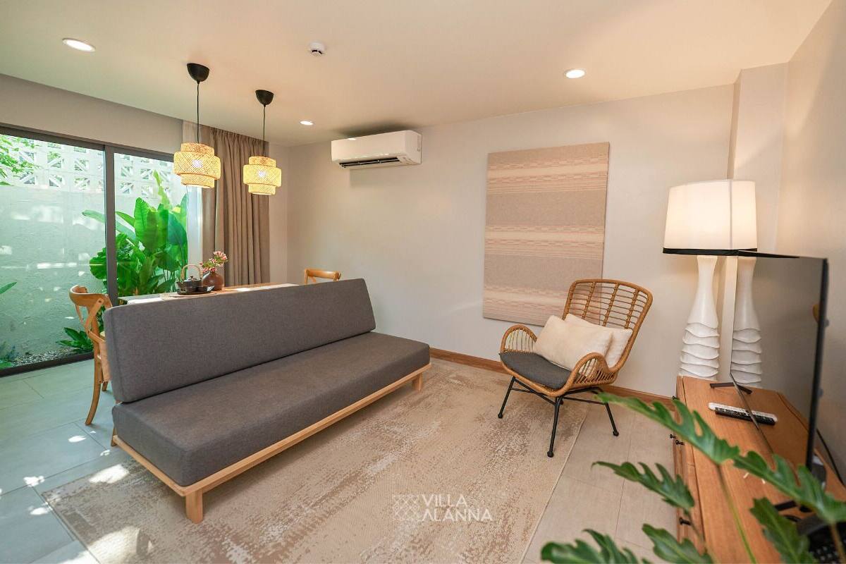 Una sala de estar moderna con un sofá, una silla, una lámpara y un televisor.