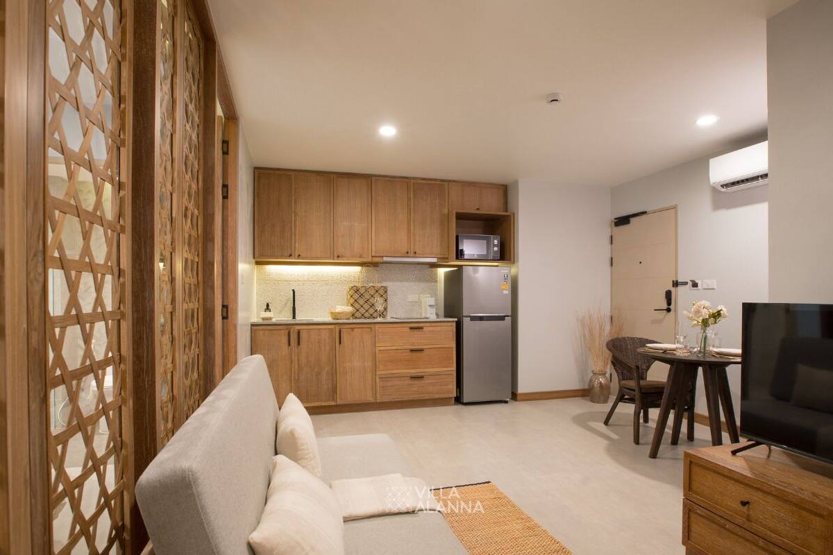 Una sala de estar moderna con un sofá, una televisión y un comedor con mesa y sillas.