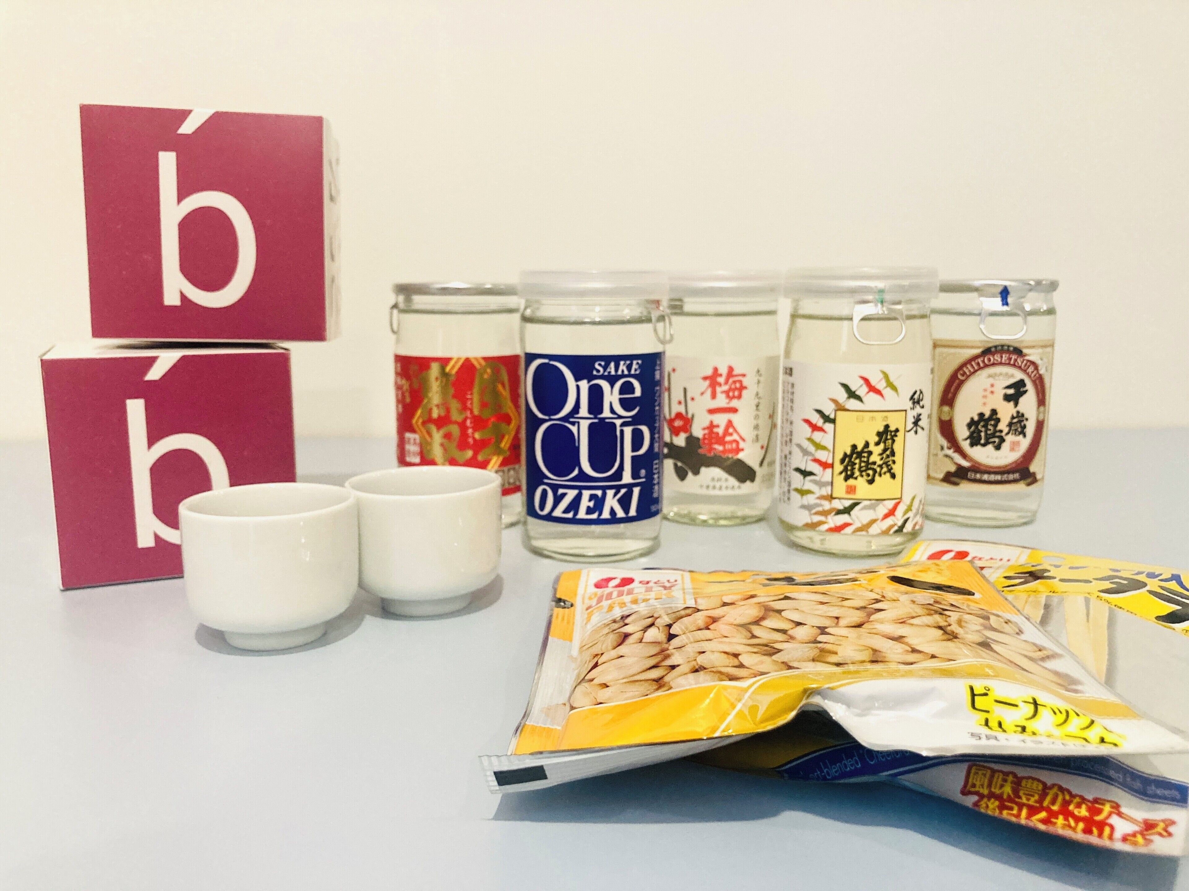 A table with various Japanese food items, including packaged snacks and glass containers with labels.