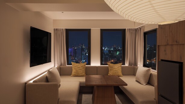 A modern living room with a sofa set, a wooden coffee table, and a large TV screen. - The Onefive Osaka Shinsekai (Osaka)
