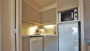 A compact kitchen with a dishwasher, a microwave, and a coffee maker on the countertop. - 2-room apartment with balcony and ski-in/ski-out access, 5 people (Avoriaz)